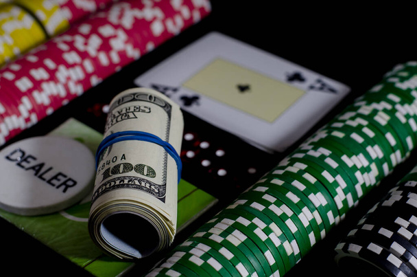 100 dollarin kupurs on blackjack-pöydällä pelimerkkien ja jakajan sirun vieressä
 - Valokuva, kuva