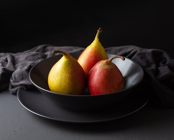 Three fresh seasonal pears on a dark background - Φωτογραφία, εικόνα