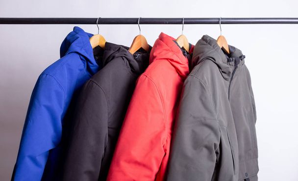 family concept or showroom of down jacket winter parka hanging on a hanger in the wardrobe - Photo, Image