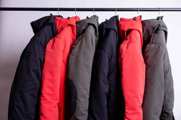 семейная концепция или выставочный зал зимней куртки на вешалке в гардеробе
 - Фото, изображение