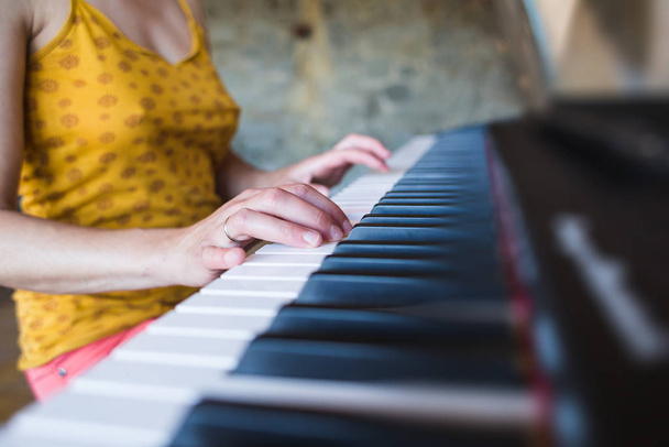 A woman learns to play the piano. - Foto, Bild