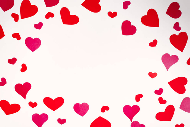 Ιστορικό του χαρτιού κόκκινο και ροζ καρδιές διαφορετικών μεγεθών σε λευκό φόντο. Κάρτα γενεθλίων με αντίγραφο χώρου για την ημέρα του Αγίου Βαλεντίνου - Φωτογραφία, εικόνα