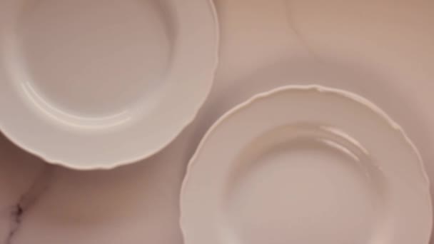 Puste białe talerze porcelanowe na marmurowym stole, dekoracje obiadowe stołowe płaskie układanki, top view food videography as recipe inspiration for cooking vlog or flatlay menu - Materiał filmowy, wideo