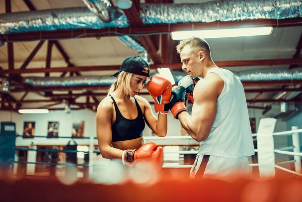 Young woman exercising with trainer at boxing and self defense lesson - Foto, Imagem