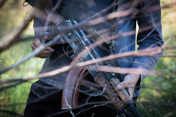 Un hombre tiene en sus manos una maqueta del arma Kalashnikov durante el entrenamiento militar voluntario conducido por veteranos de guerra soviéticos afganos en un bosque en la región de Kiev, Ucrania.
 - Foto, Imagen