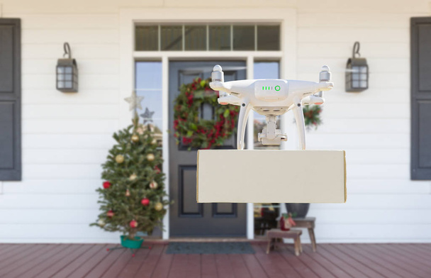 Paquete de entrega de drones al porche de la casa decorada de Navidad
 - Foto, imagen