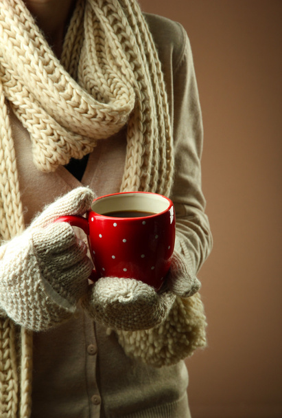 Female hands with hot drink, on color background - Фото, изображение
