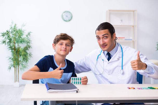 Молодий чоловік лікар вивчає хлопчика в клініці
 - Фото, зображення