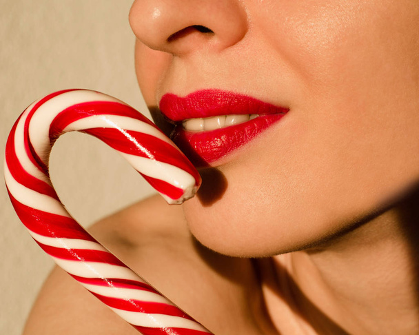 woman with christmas striped candy stick - Foto, imagen