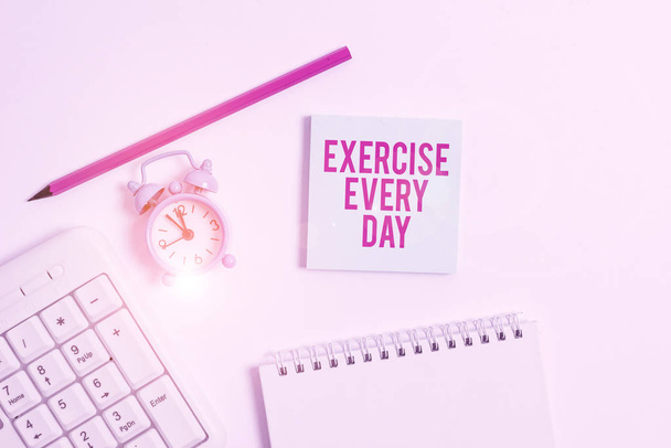Handwriting text writing Exercise Every Day. Concept meaning move body energetically in order to get fit and healthy White pc keyboard with empty note paper and pencil above white background. - Photo, Image