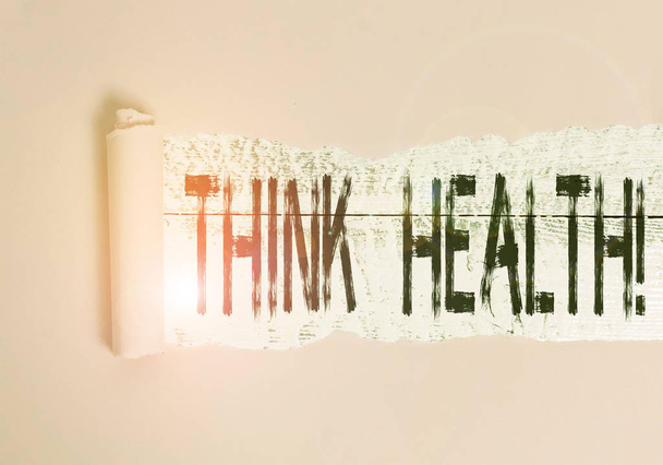 Kézírás szöveg Think Health. Koncepció jelentése: a teljes fizikai mentális és társadalmi jólét állapota Karton, amely középen egy fa klasszikus asztal fölé kerül. - Fotó, kép
