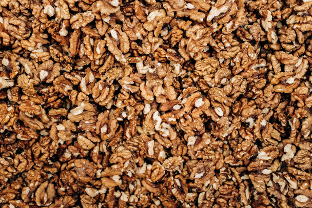 Closeup of big shelled walnuts pile. The background of their shelled walnuts. - Fotografie, Obrázek