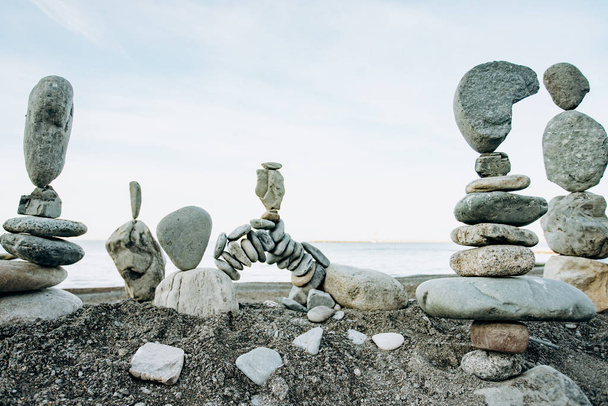Infinitely stacked stones and stone figures by the sea - Photo, Image