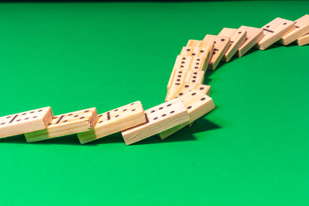 Gestürzte Dominoshow mit Holz-Dominosteinen auf Grün - Foto, Bild