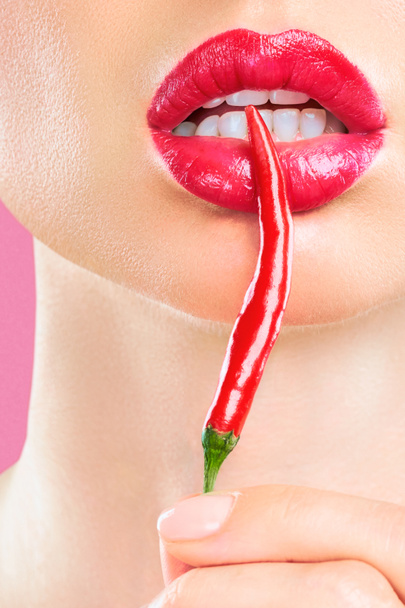 Mujer joven con chile rojo aislado en fondo pinc. Sexy labios femeninos. Chica seductora caliente
 - Foto, Imagen