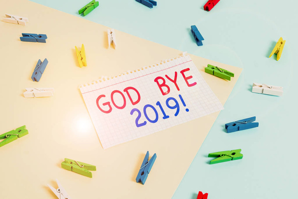 Kézírás szöveg Isten Bye 2019. Koncepció jelentése kifejezni jó kívánságait, amikor elválnak, vagy a végén a tavalyi Színes ruhacsap papír üres emlékeztető sárga kék padló háttér iroda. - Fotó, kép