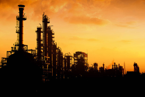 Κλάδο των διυλιστηρίων πετρελαίου και φυσικού αερίου σε εικόνας silhouette σε ουρανό πορτοκαλί φόντο ηλιοβασίλεμα, πετροχημικό εργοστάσιο, εργοστάσιο με το βράδυ - Φωτογραφία, εικόνα