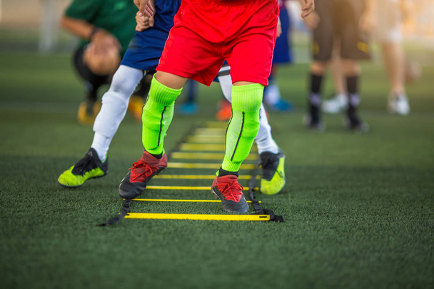 Дитячі футболісти біжать і стрибають між маркерів для ніг
 - Фото, зображення