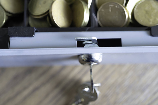 Cashbox κλειδαριά με κλειδιά και γεμάτη κέρματα - Φωτογραφία, εικόνα