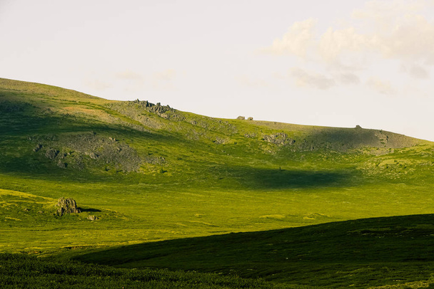 Delikatne zielone wzgórza. Dolina górska na pastwiska z miękkimi zboczami pokrytymi zieloną trawą - Zdjęcie, obraz