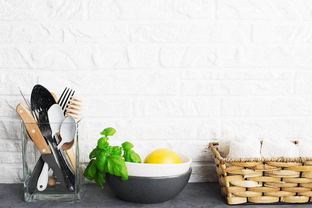 Simple minimalist kitchen shelf. Cutlery, kitchen tools, greens in a glass, fruits on a light background. Scandy style. Home comfort, - Valokuva, kuva