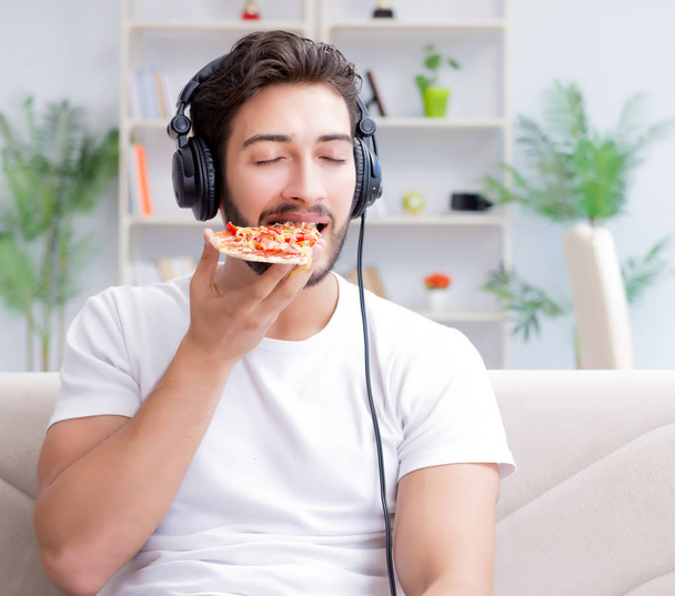 Mies syö pizzaa ottaa noutoruokaa kotona rentouttava lepo - Valokuva, kuva