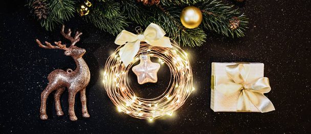 Decorazioni di Natale o Anno nuovo su sfondo scuro: Albero di Natale, decorazioni d'oro, renne, ghirlanda, regalo
 - Foto, immagini