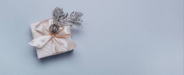 Vánoční kompozice.Malá dárková krabička s vánoční výzdobou, smrková stříbrná větev na světle modrém pozadí. Minimalismus, plochá lež. Nápis - Fotografie, Obrázek