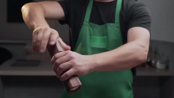 Koch verwendet Salzmühle, um etwas Salz für seine Mahlzeit hinzuzufügen - Filmmaterial, Video