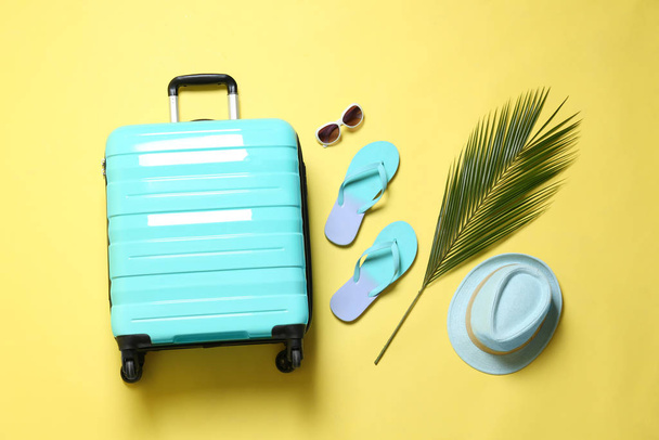 Flat lay composition with suitcase on yellow background - Foto, immagini