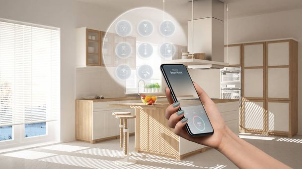 Intelligens otthoni technológia interfész a telefon app, kiterjesztett valóság, internet a dolgok, belső kialakítás a modern konyha összekapcsolt tárgyakkal, női kéz távirányító eszköz - Fotó, kép