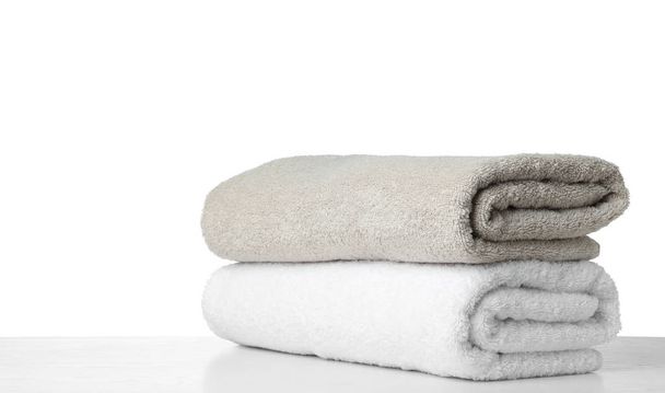 Folded fresh clean towels for bathroom on table against white ba - Photo, Image