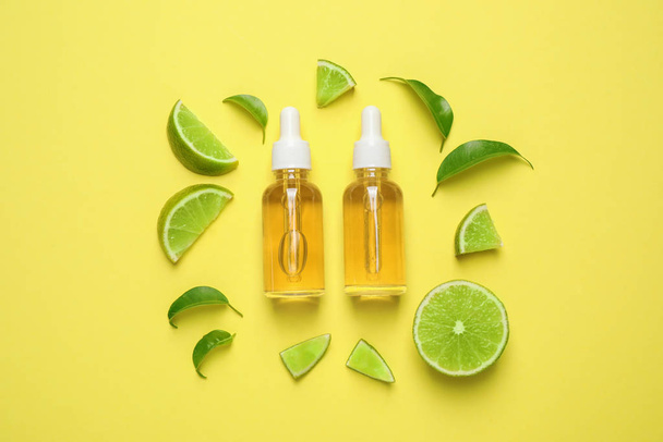 Flat lay composition with lime essential oil on yellow background - Foto, afbeelding