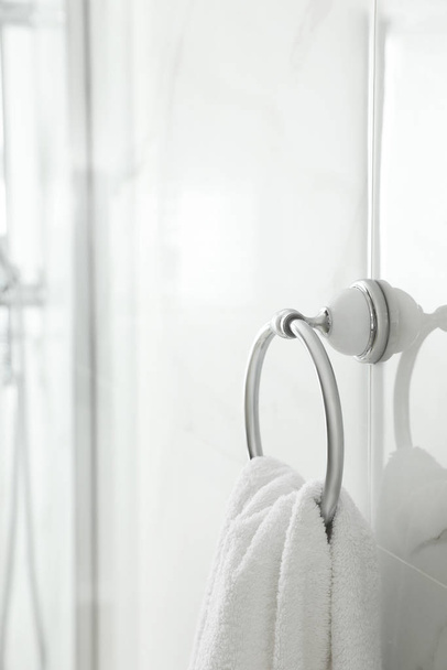 Holder with clean towel on light wall in bathroom. Space for tex - Foto, Imagen