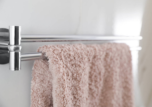 Holder with clean towel on light wall in bathroom, closeup - Foto, immagini