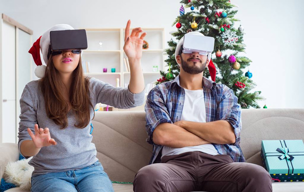 Happy family using virtual reality VR glasses during christmas - Photo, Image