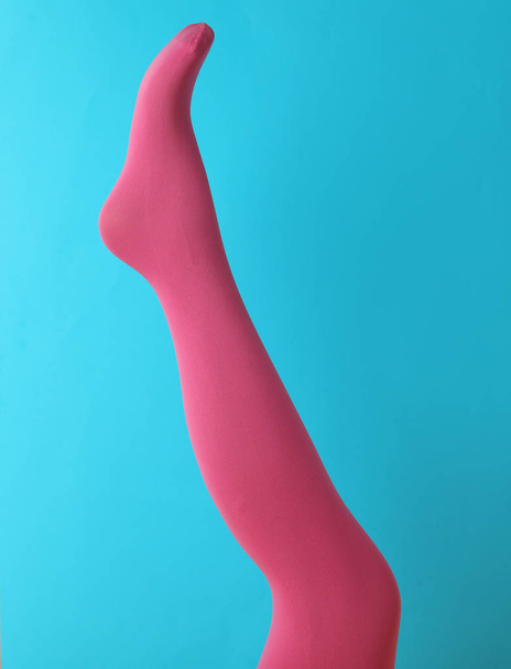 Leg mannequin in pink tights on blue background - Φωτογραφία, εικόνα