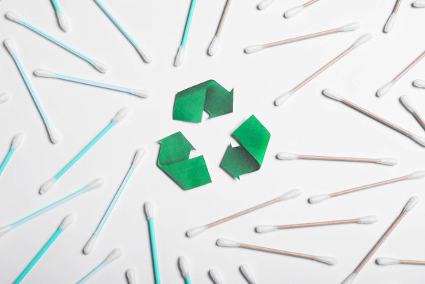 Recycling symbol, plastic and wooden cotton swabs on white background, top view - Foto, afbeelding