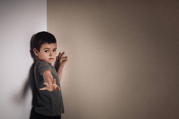 Little boy in corner near yellow wall, space for text. Child in danger - Fotoğraf, Görsel