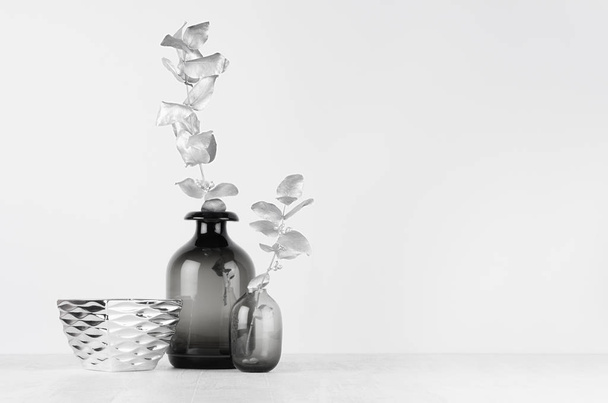 Elegant black and white home decor - black glass vase decorated silver leaves, bowl on light white wood table. - Foto, Imagem