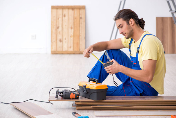 Young male contractor working indoors - Foto, afbeelding