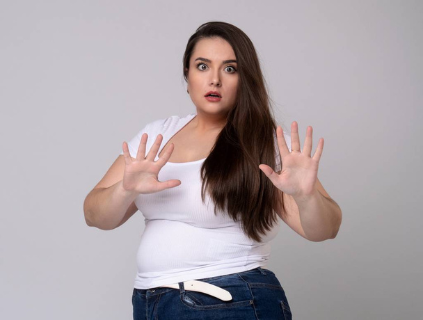 Plus Size Model with long hair gesturing no signal in studio. - Photo, image