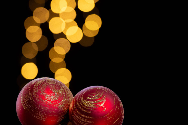 zwei rote Christbaumkugeln mit goldener Dekoration in dunkler Umgebung - Foto, Bild