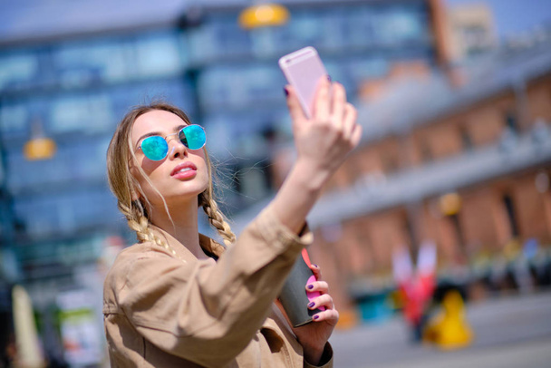 Happy young woman taking selfie on street - Photo, image