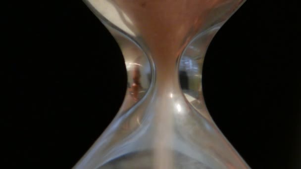 Hourglass μετρώντας το χρόνο σε ακραία γκρο πλαν, μαύρο φόντο - Πλάνα, βίντεο