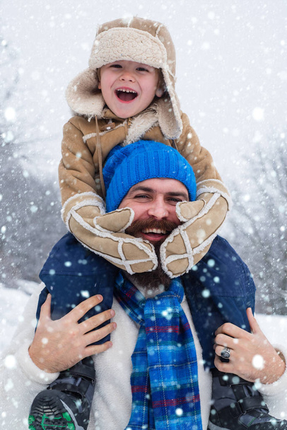 Daddy and boy smiling and hugging. Christmas holidays and winter new year with father and son. Winter scene on white snow background. - Photo, Image