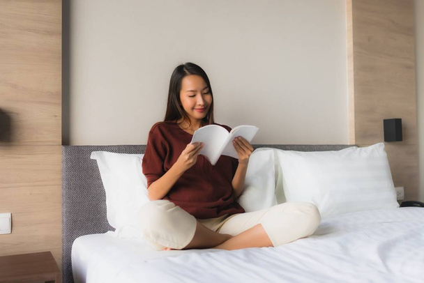 Πορτρέτο όμορφες νεαρές Ασιάτισσες διαβάζουν βιβλίο στο κρεβάτι - Φωτογραφία, εικόνα