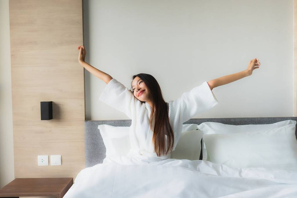 Πορτρέτο όμορφες νεαρές Ασιάτισσες χαρούμενο χαμόγελο χαλαρώστε στο κρεβάτι - Φωτογραφία, εικόνα