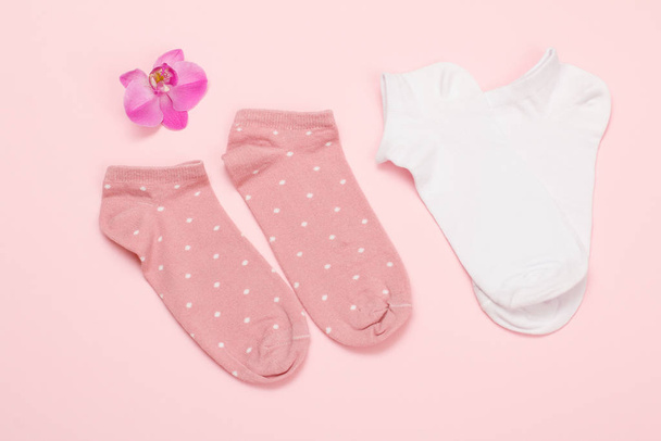 Two pairs of women socks on pink background. - Фото, изображение
