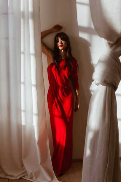 Beautiful young woman in long red dress - Foto, Bild